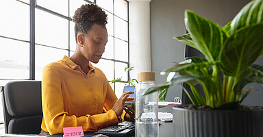 Neues in den digitalen Meldeverfahren: Frau sitzt im Büro vor einem Bildschirm Neues in den digitalen Meldeverfahren: Frau sitzt im Büro vor einem Bildschirm