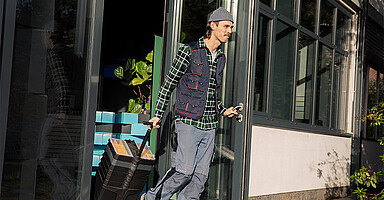 Online-Seminar „Ende von Beschäftigungen“: Mann mit Rollkoffer verlässt ein Gebäude. Online-Seminar „Ende von Beschäftigungen“: Mann mit Rollkoffer verlässt ein Gebäude.