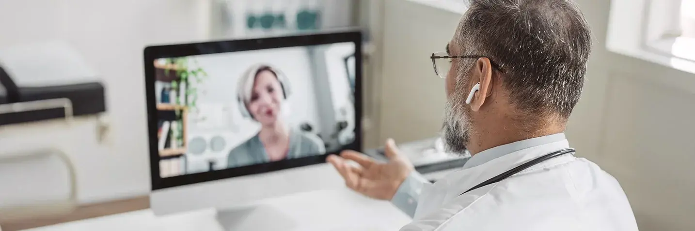 Arzt im Videogespräch mit einer Patientin Das Bild zeigt einen Arzt im Videogespräch mit einer Patientin