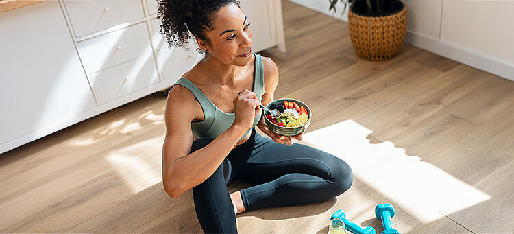 Fit in den Frühling: Sportlich gekleidete Frau macht eine Essenspause