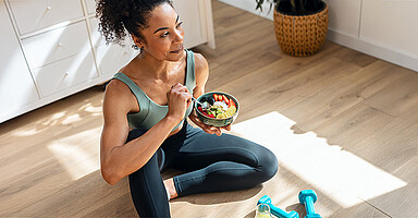 Fit in den Frühling: Sportlich gekleidete Frau macht eine Essenspause