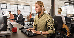 SV-Informationen für Arbeitgeber: Mann am Computer im Großraumbüro SV-Informationen für Arbeitgeber: Mann am Computer im Großraumbüro