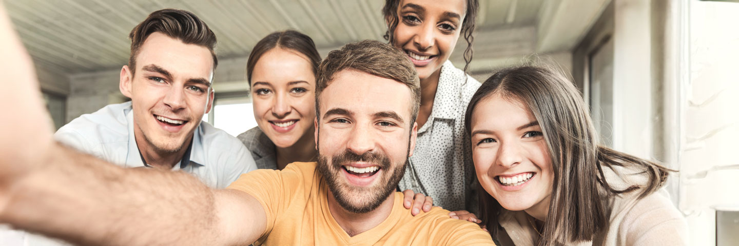 Eine Gruppe von jungen Beschäftigten macht ein Selfie