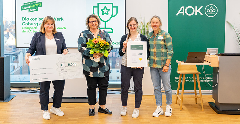 Preisverleihung „GesundMACHER Award“: Eine Gruppe von Frauen präsentiert einen Gewinnerscheck