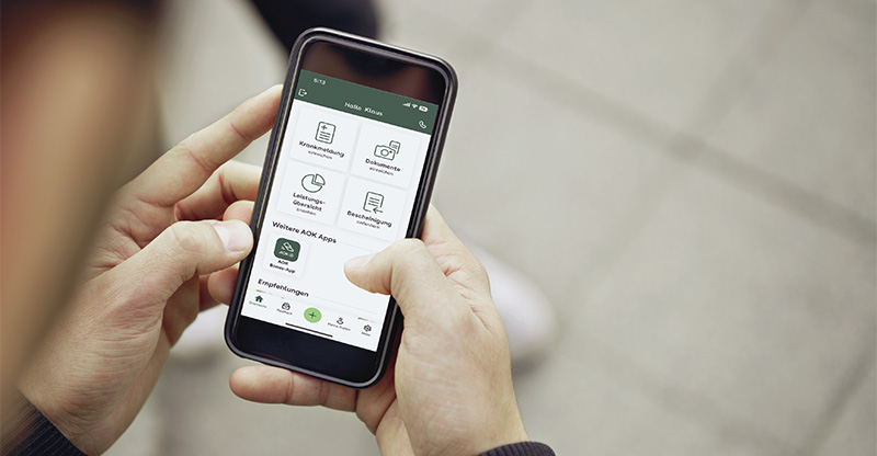 Jemand öffent eine AOK-Webseite am Smartphone