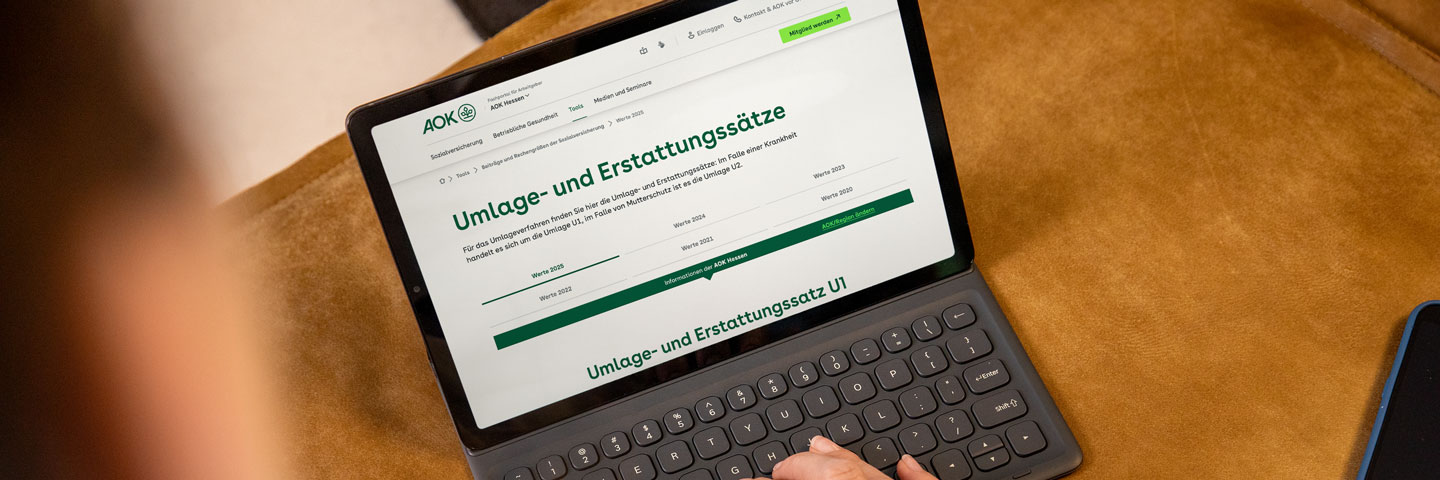 Umlagesätze 2025 der AOK Hessen: Offener Laptop zeigt aktuelle Beitragssätze.