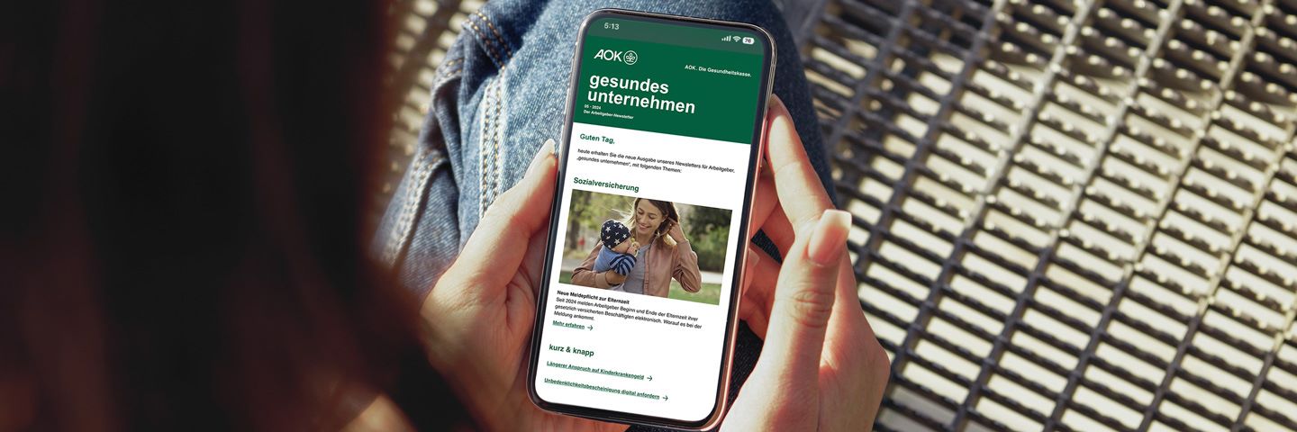 Blick auf ein Smartphone mit dem AOK-Newsletter für Arbeitgeber.