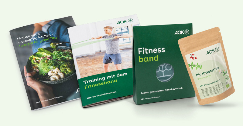 Ein Fitnessband, ein Kräutertee und ein Rezept-Booklet der AOK gehören zu dem Set