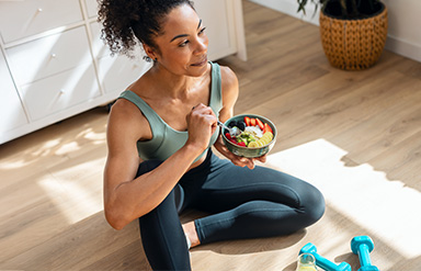 Fit in den Frühling: Sportlich gekleidete Frau macht eine Essenspause