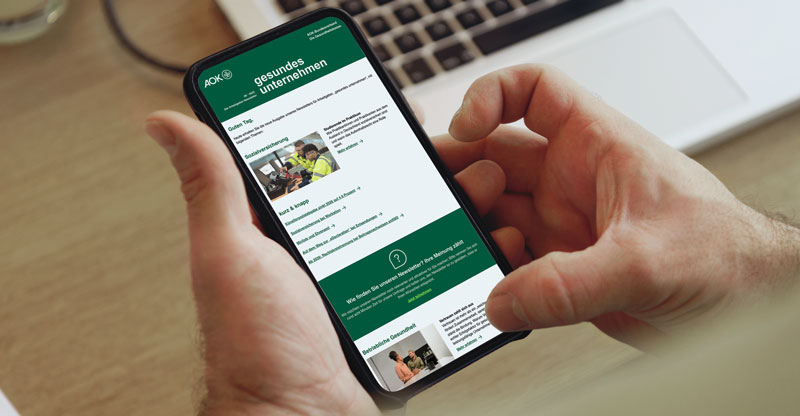 Newsletter gesundes unternehmen abonnieren: Hände halten ein Smartphone, auf dem Display ist der Newsletter zu sehen. Newsletter gesundes unternehmen abonnieren: Hände halten ein Smartphone, auf dem Display ist der Newsletter zu sehen.
