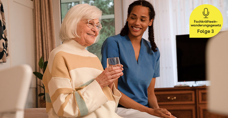 Eine ältere Frau und eine Pflegerin in einem Wohnzimmer