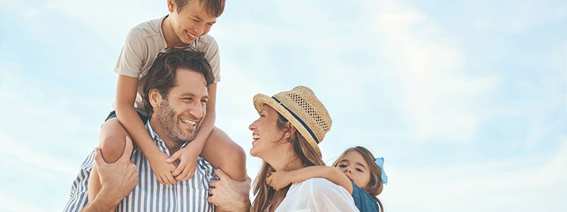 AOK-Urlaubsplaner: Vierköpfige Familie vor blauem Himmel