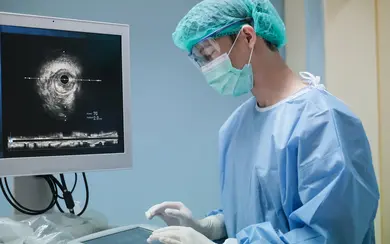 Arzt, der an der intravaskulären Ultraschallbildgebung (IVUS) im Herzkatheterlaborraum arbeitet.