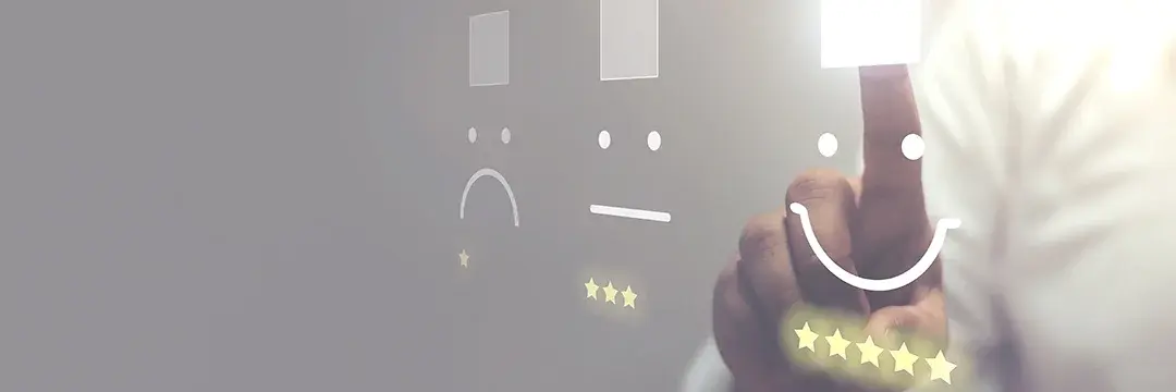 Ein Mann drückt zur Bewertung auf Smileys auf einem Touchscreen. 