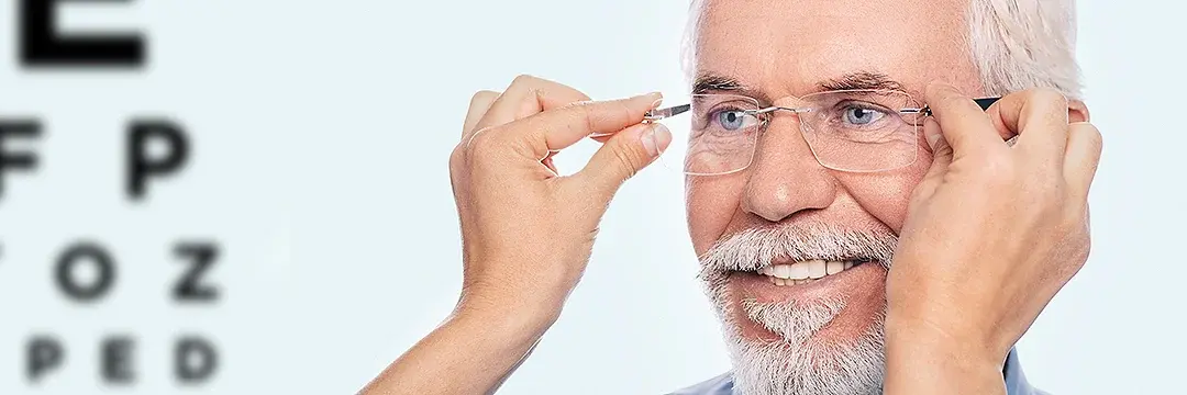 Optiker setzt älterem Mann neue Brille auf