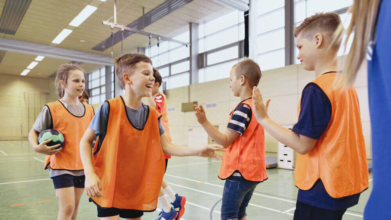 Kinder klatschen sich beim Sport gegenseitig ab