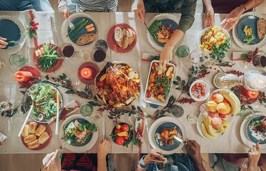 Draufsicht auf einem großen Tisch, auf deim ein festliches Essen steht.