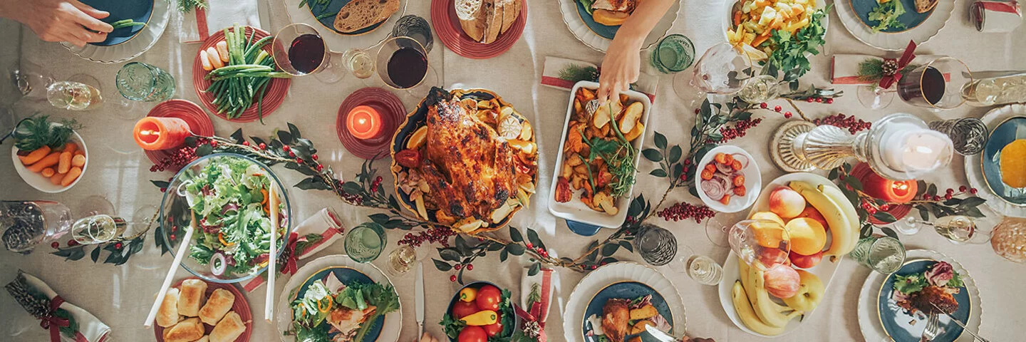 Draufsicht auf einem großen Tisch, auf deim ein festliches Essen steht.