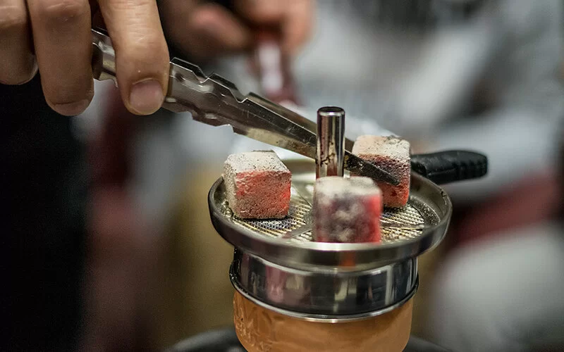 Nahaufnahme heißer Kohlewürfel, die sich in einer Shisha befinden.