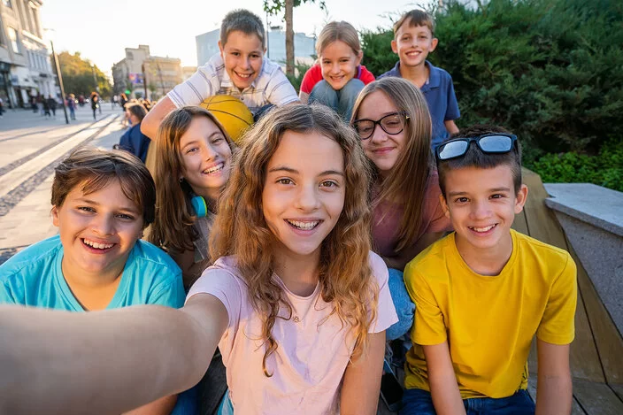 Eine Gruppe junger Jugendliche macht ein Selfie.