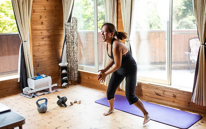 Eine Frau macht ein Zumba Work-Out in ihrem Wohnzimmer.