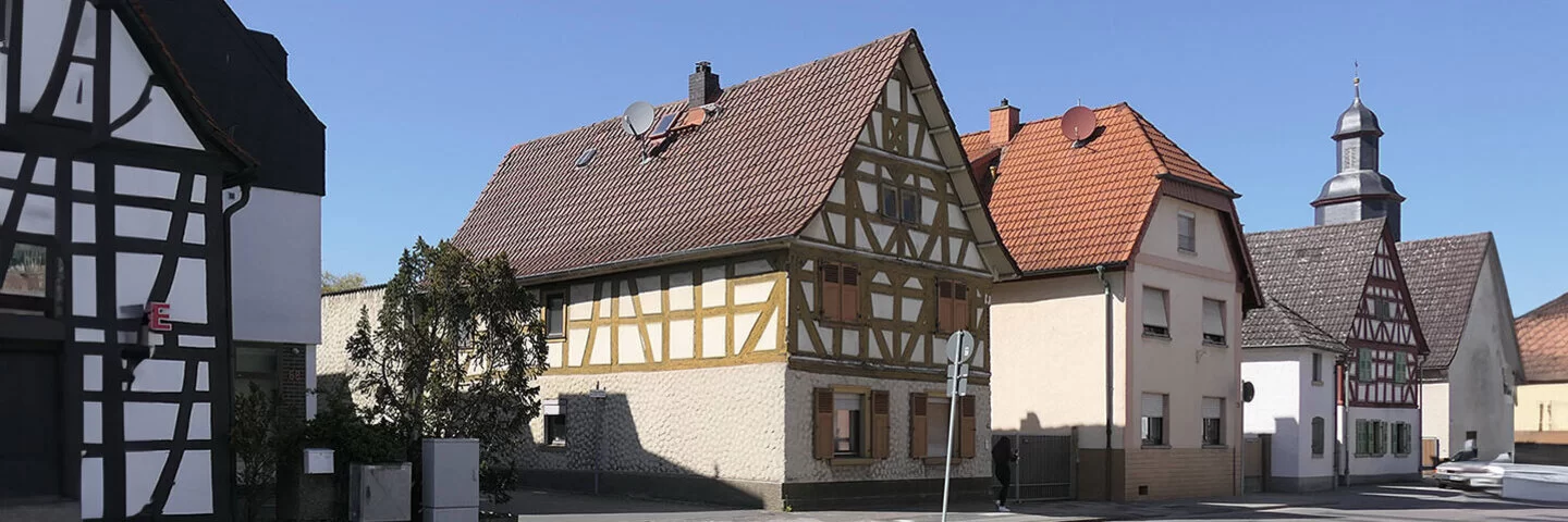 Nebeneinanderstehende Fachwerkhäuser an einer breiten Straße in Rodgau.