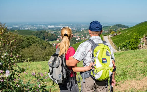 Ein Paar mit Rucksäcken genießt einen Spaziergang im Naturpark Schwarzwald, die Aussicht ist atemberaubend und einladend.