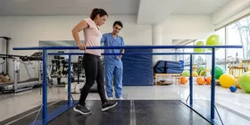 Frau absolviert ein kräftigenden Gehtraining bei einer Rehabilitationsmaßnahme.