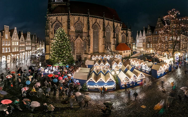 Der Lamberti-Weihnachtsmarkt bei Abend vor der St. Lamberti-Kirche.