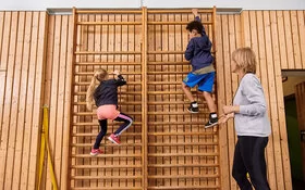 Kinder machen zusammen mit einer Lehrerin Sport. Beim Präventionsprogramm „Henrietta & Co.“ erfahren sie, warum Bewegung und gesunde Ernährung wichtig sind.