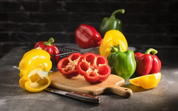 Paprika in verschiedenen Farben liegen auf einer Küchenarbeitsplatte.