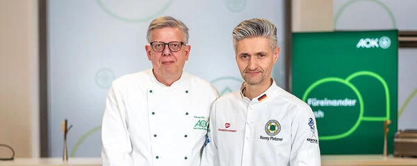 Weltmeister-Koch Ronny Pietzner (rechts) und Ernährungsexperten Andreas Bös (links) lächeln in die Kamera.