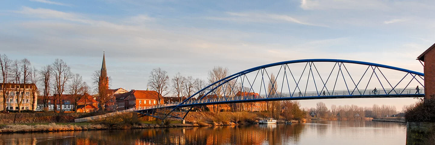 Abendsonne in der Kleinstadt Nienburg mit Kirche und Fußgängerbrücke an der Weser