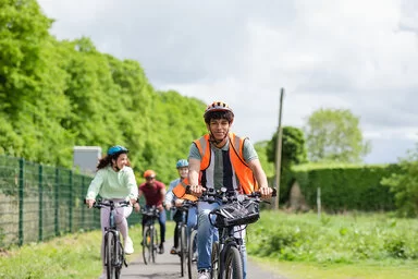 Eine Gruppe Radfahrer ist auf einer gemeinsamen Radtour unterwegs. Sie fahren auf einem ruhigen Fahrradweg.