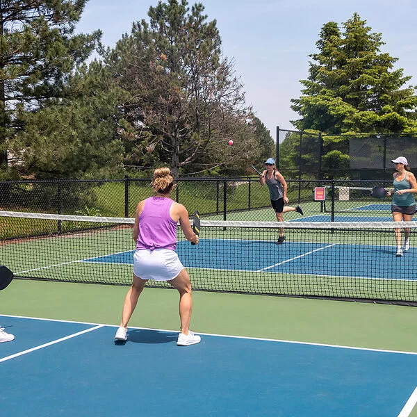 Jeweils zwei Spielerinnen stehen sich auf einem Pickleballfeld bei einem Doppel gegenüber.