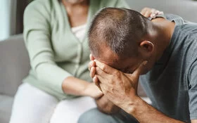 Ein nachdenklich wirkender, junger Mann sitzt auf einer Bank. Der Familiencoach Depression hilft dabei, den Alltag mit einem depressiv erkrankten Menschen besser zu bewältigen.