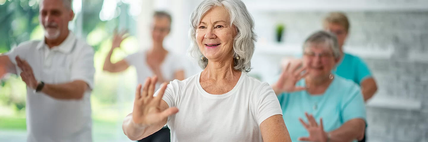 Eine Gruppe älterer Menschen praktiziert Tai Chi.