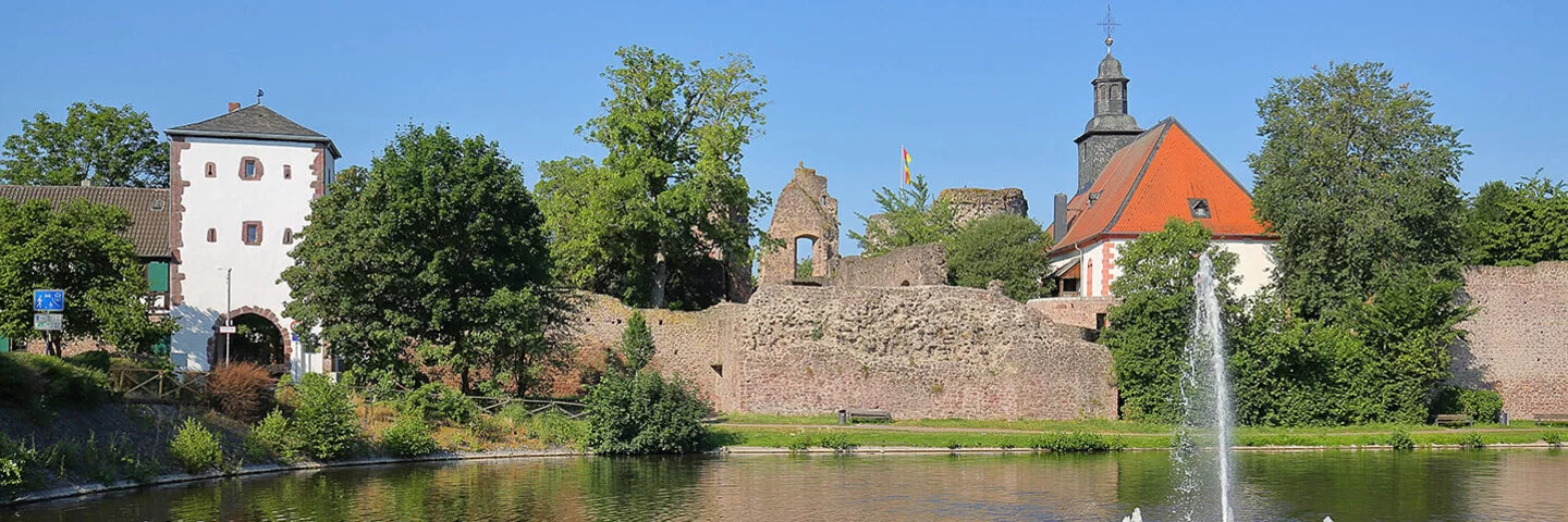 Blick auf den Burgweiher, die Burgkirche sowie die Ruine von Burg Hayn in Dreieichenhain, einem Stadtteil von Dreieich.