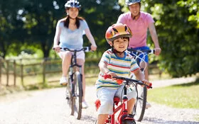 Eine Familie mit einem kleinen Sohn ist mit dem Rad unterwegs.