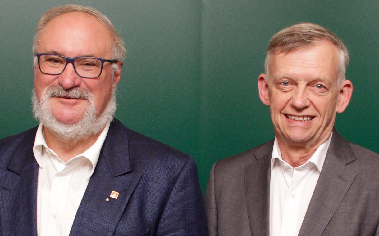 Das Foto zeigt die beiden alternierenden AOK-Verwaltungsratsvorsitzenden Lutz Schäffer (links im Bild) und Johannes Heß vor einem grünen Hintergrund.
