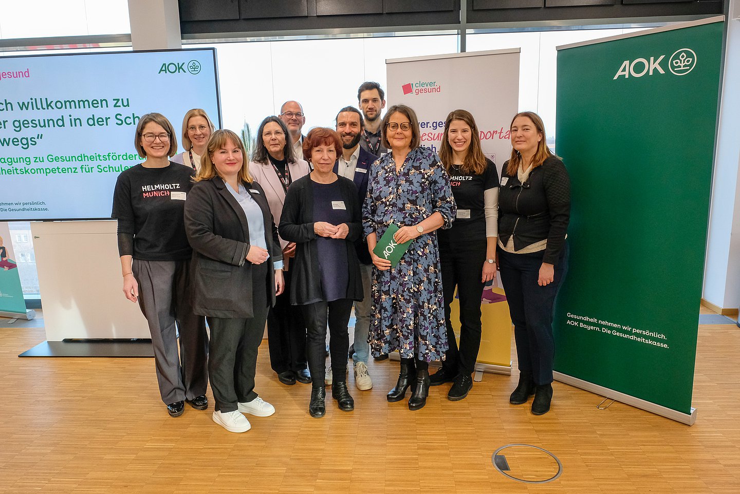 Auf dem Gruppenfoto zur 1. Fachtagung „Clever gesund in der Schule unterwegs“ von links nach rechts: Verena Braun (Helmholtz Munich, clever.gesund), Dr. Marie Standl (Helmholtz Munich, Institut für Epidemiologie), Annette Lutz (AOK Bayern, Bereichsleiterin Gesundheitsförderung), Petra Westhäuser (Direktorin staatl. Realschule für Knaben, Immenstadt), Nico Waibel (Bayerisches Staatsministerium für Unterricht und Kultus, Leiter Referat VI.8), Ulrike Koller (Helmholtz Munich, clever.gesund), Andreas Nagel (AOK Bayern, Referent Lebenswelten), Dr. Jan Ellinger (TU München, Bereich Sport und Gesundheitsdidaktik), Silke Recksiek (AOK Bayern, Geschäftsbereichsleiterin Marke und Kundenerlebnis), Amelie Krause (Helmholtz Munich, clever.gesund), Stefanie Reiffert (Helmholtz Munich, clever.gesund)