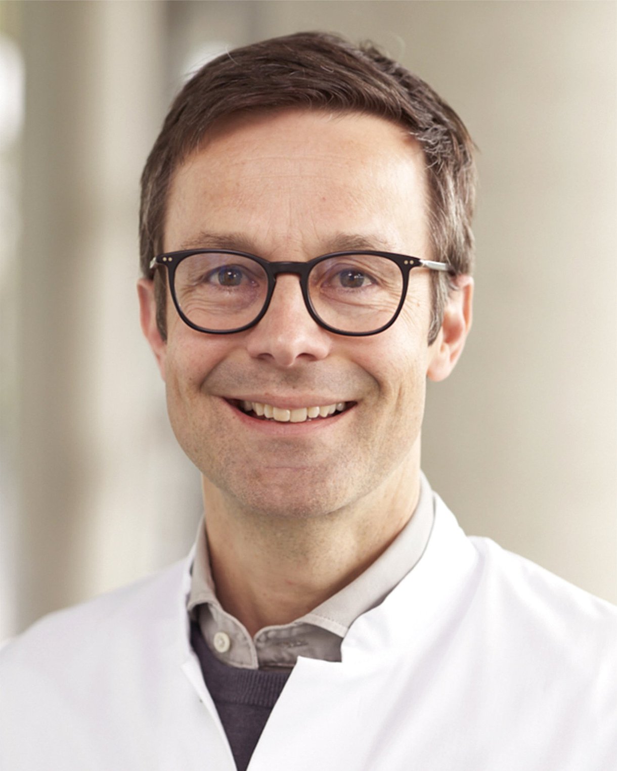 Porträt von Prof. Dr. Michael Denkinger, bei dem er freundlich in die Kamera lächelt