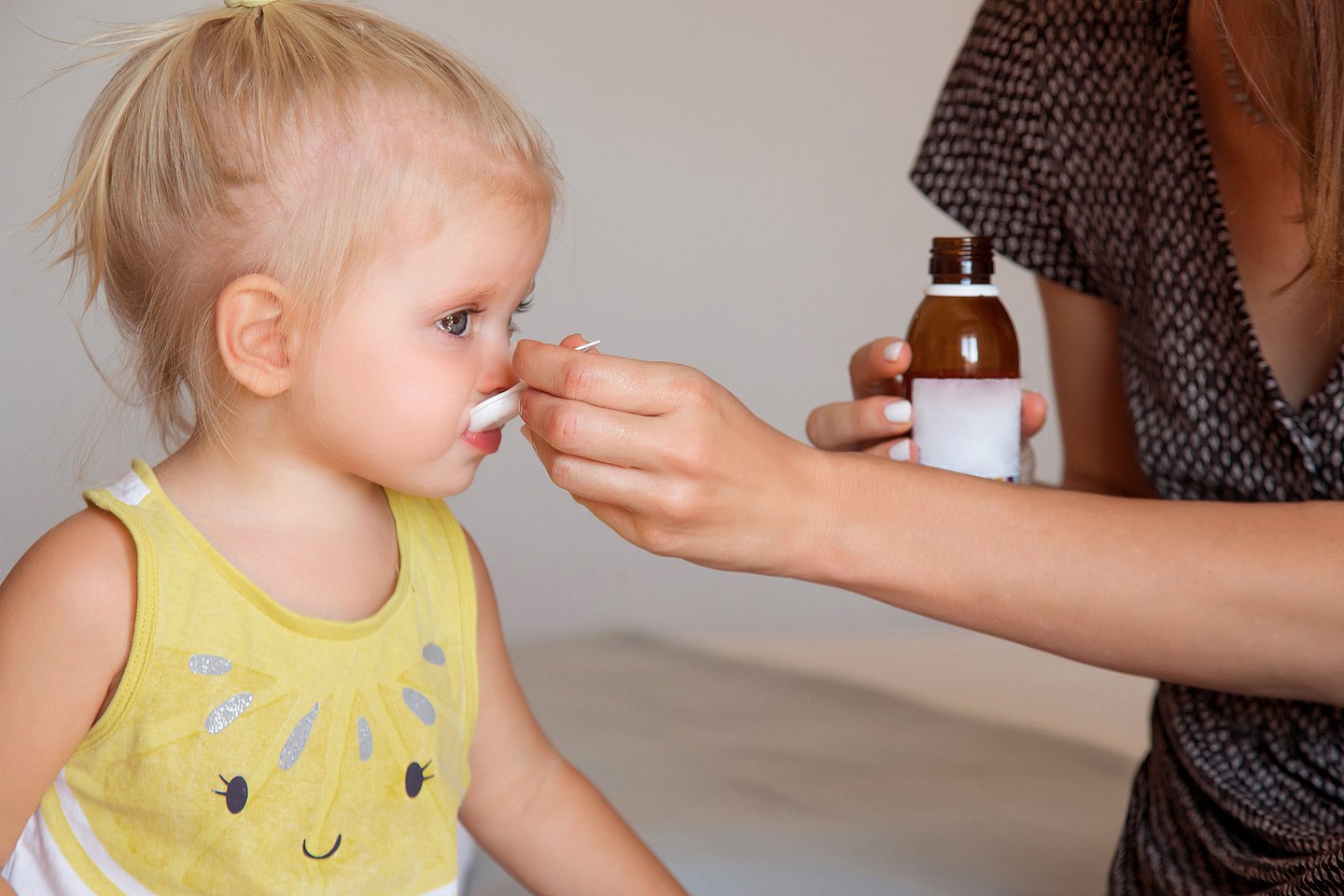 Foto: Ein Kleinkind erhält mit einem Löffel einen Medikamentensaft.