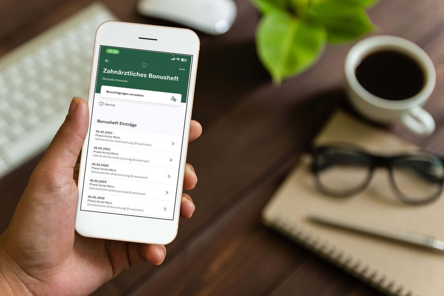 Auf einem Handy-Display werden die Einträge aus dem zahnärztlichen Bonusheft angezeigt.