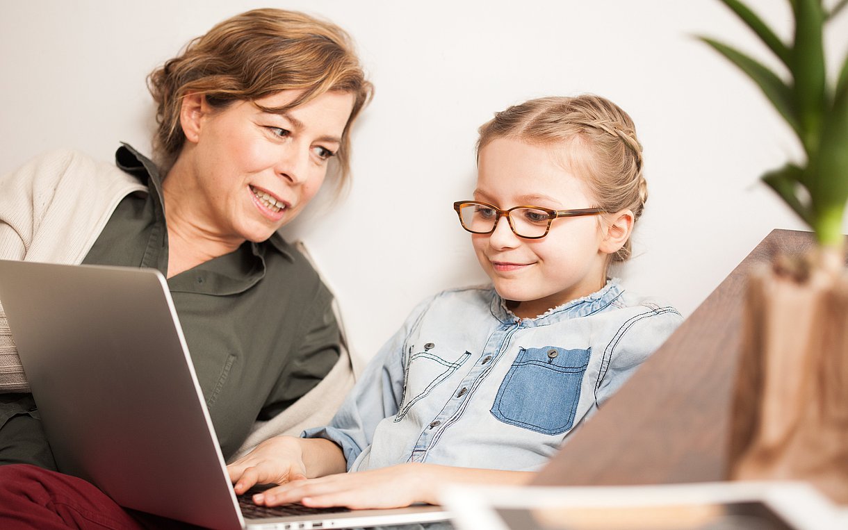 Mutter und Kind vor einem Laptop