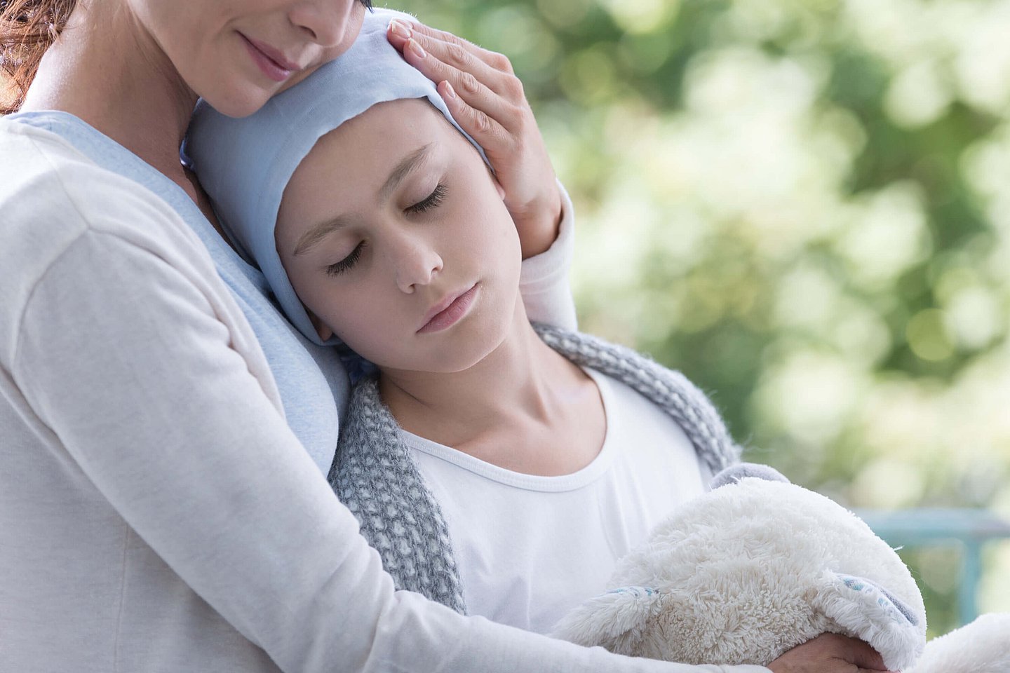 Eine Mutter hält ihr krebskrankes Kind im Arm.