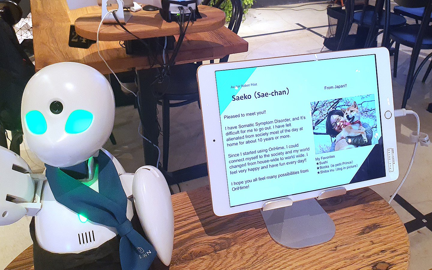 Foto eines Tischroboters. Daneben sind auf einem Tablet Informationen von Saeko zu sehen, die den Roboter steuert.
