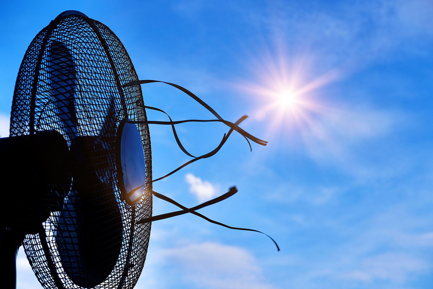 Symbolbild Hitze: Ventilator vor der Sonne am blauen Himmel