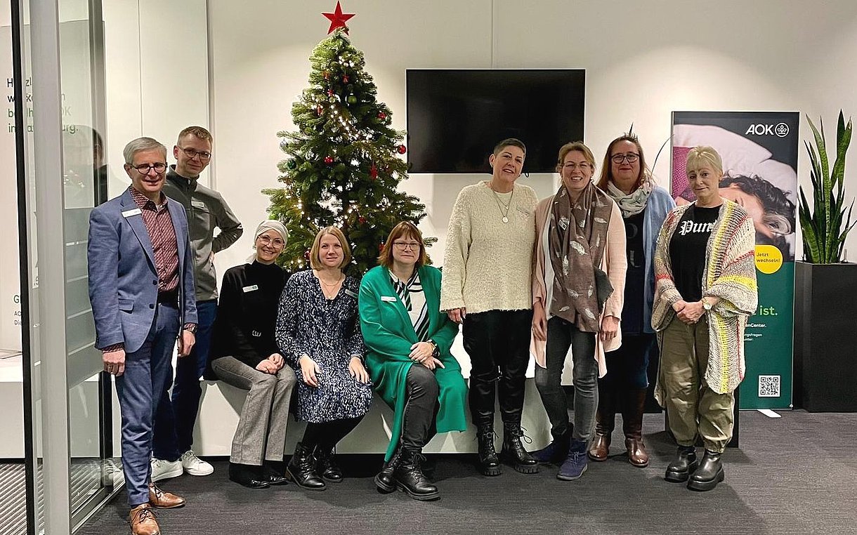 Das Team des Kunden-Centers Ravensburg gruppiert sich um einen Weihnachtsbaum.