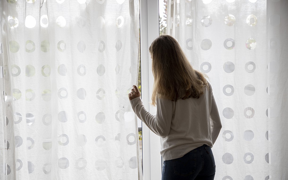 Ein Frau steht vor einem Fenster